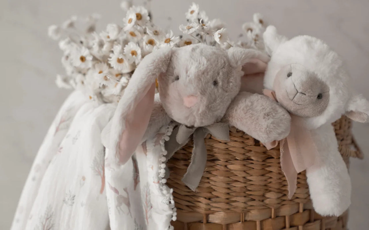 Soft plush bunny and lamb baby gifts styled with neutral nursery décor and elevated bohemian baby aesthetic.