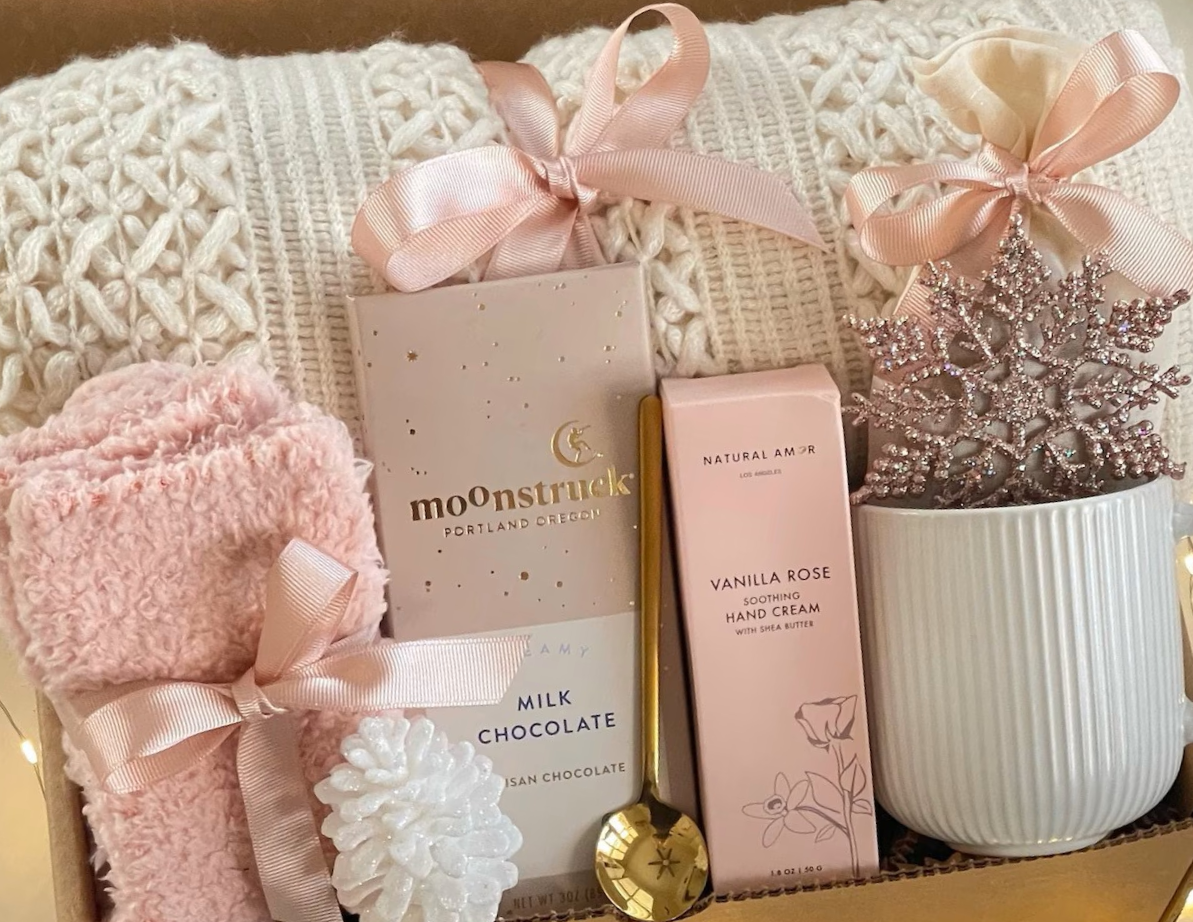 Curated luxury gift basket from Crooked Halos featuring cozy knit textiles, artisan chocolate, vanilla rose hand cream, and feminine bohemian gifts.