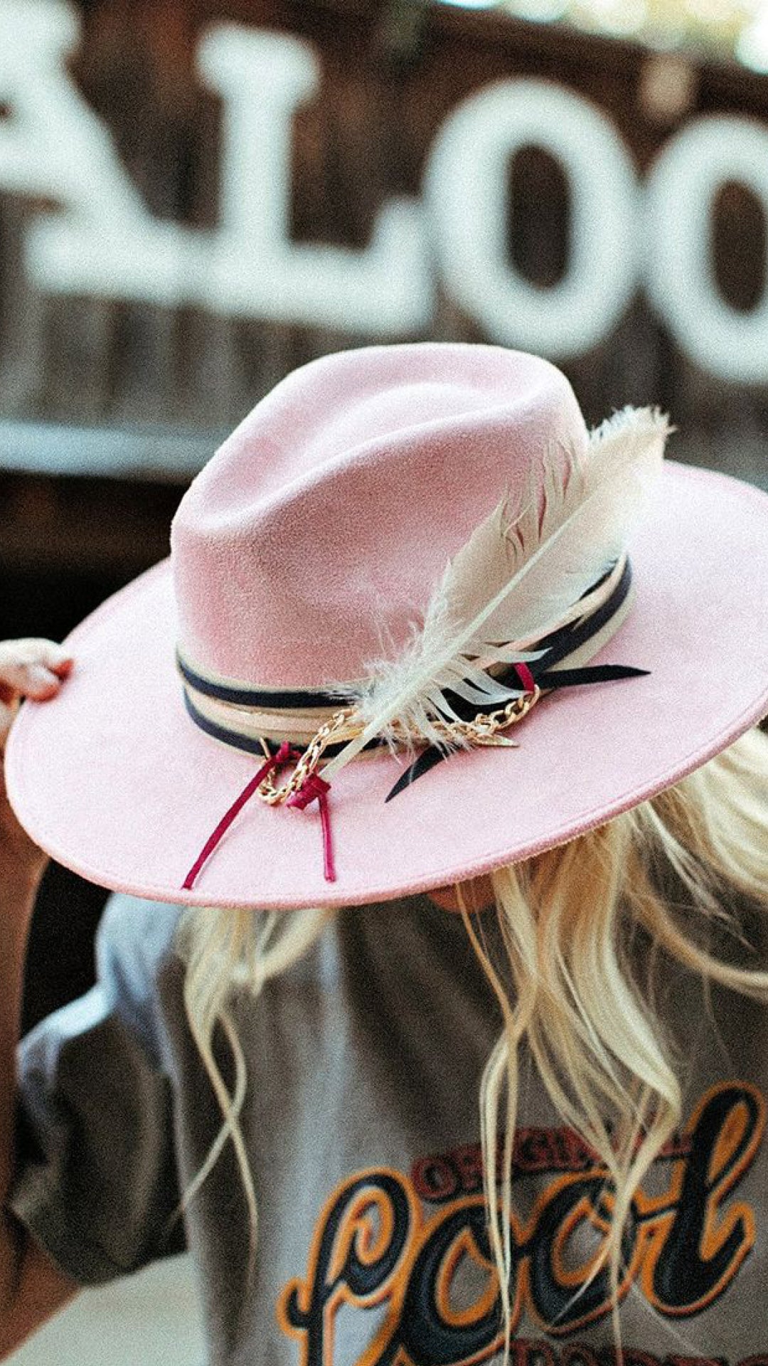 Blush pink bohemian cowgirl hat with feather detailing and western-inspired styling photographed in an elevated coastal cowgirl aesthetic.